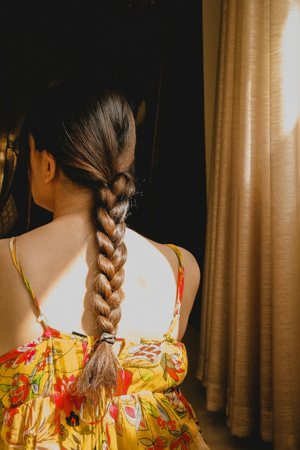 a woman with a fishtail braid in a yellow dress