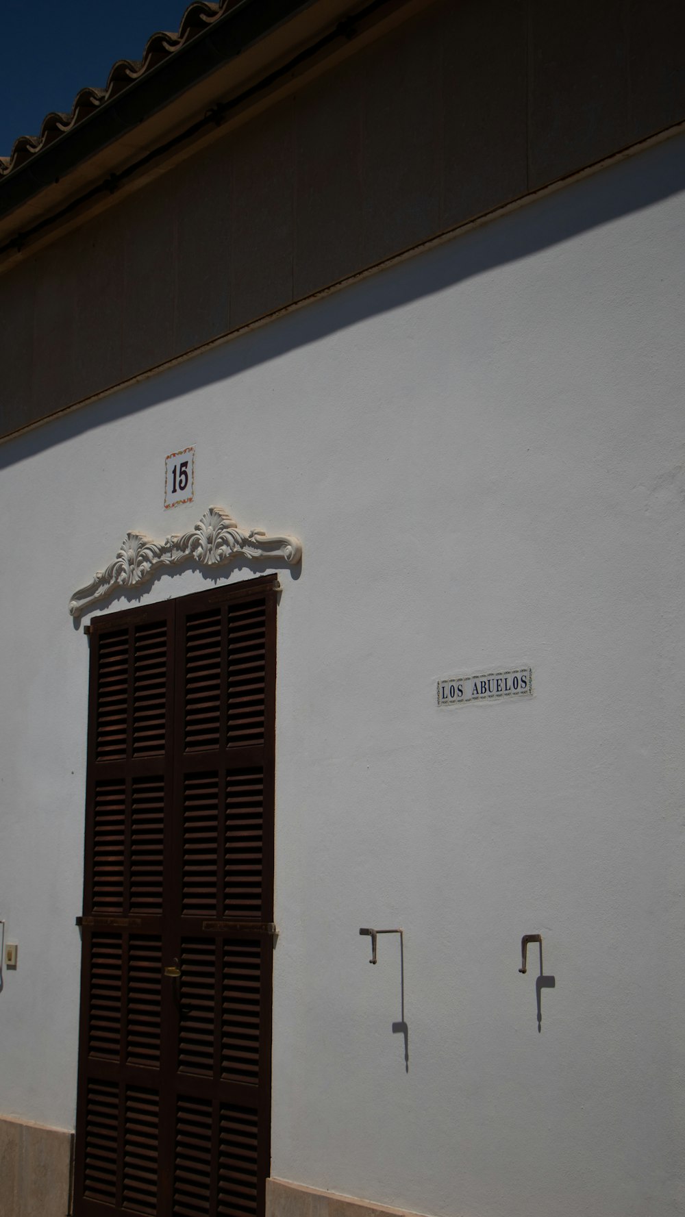 a white building with a brown wooden door