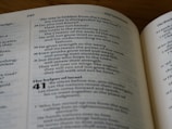 Text from an open book is visible, displaying passages with chapter and verse numbers. The pages are part of the Bible's Old Testament, specifically Isaiah 40. The font is a standard serif type, and the text is arranged in two columns on each page.