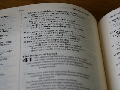 Text from an open book is visible, displaying passages with chapter and verse numbers. The pages are part of the Bible's Old Testament, specifically Isaiah 40. The font is a standard serif type, and the text is arranged in two columns on each page.