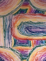 A close-up of Prashalee's hand sketching abstract lines with vibrant colors around.