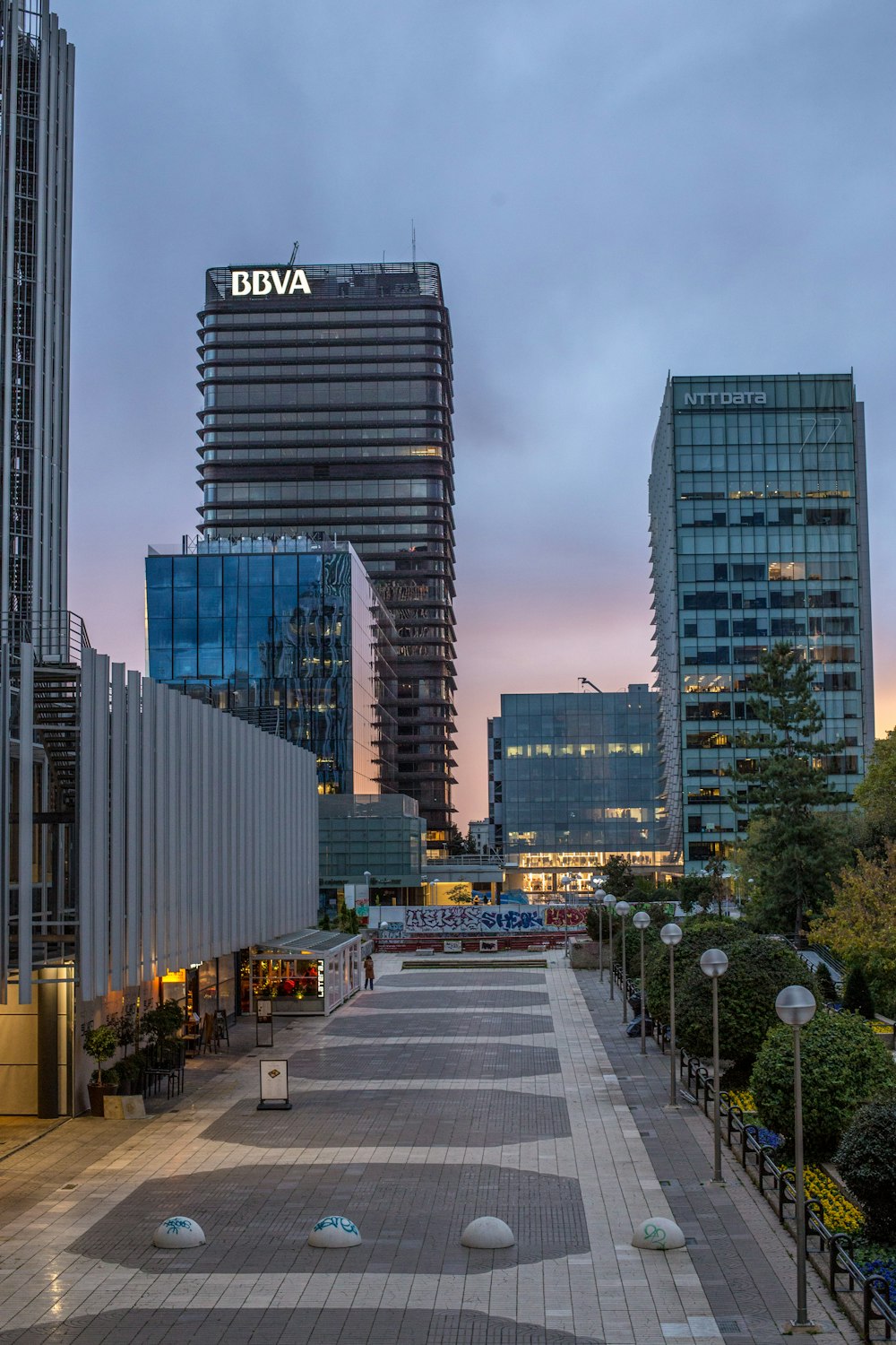 a city street lined with tall buildings at dusk