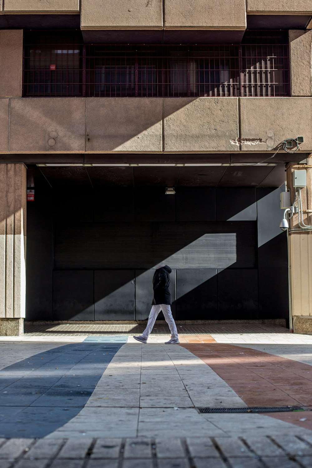 a person walking down a sidewalk in front of a building