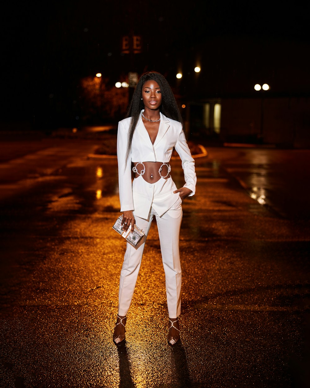 a woman in a white suit standing in the rain