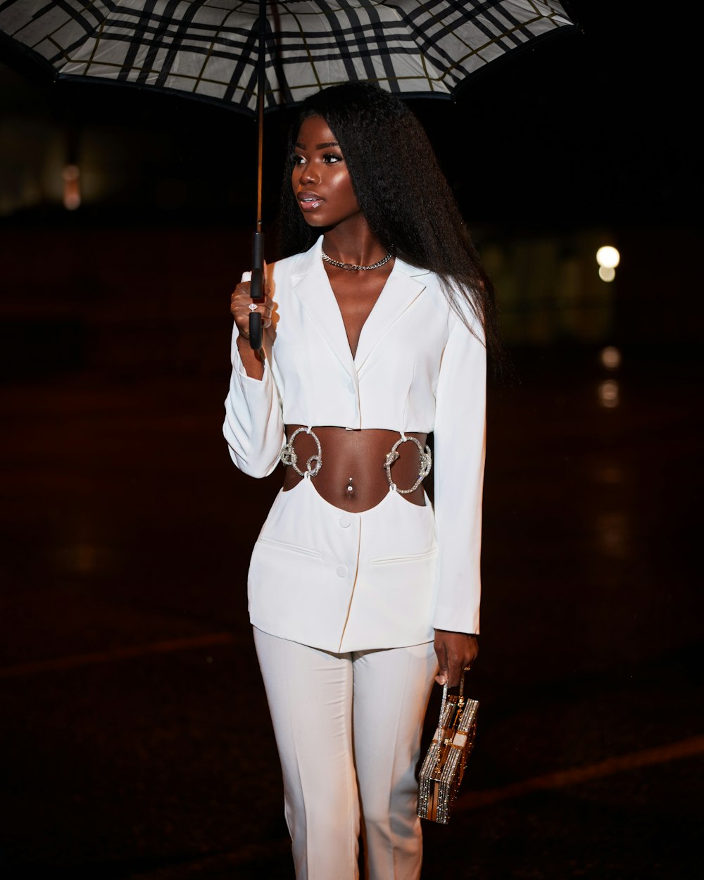 a woman in a white suit holding an umbrella