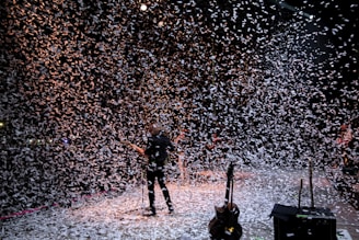 a man standing on a stage surrounded by confetti