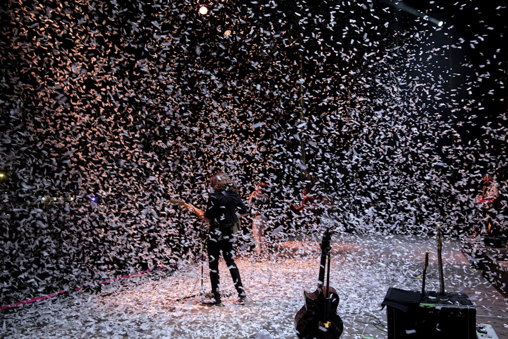 a man standing on a stage surrounded by confetti