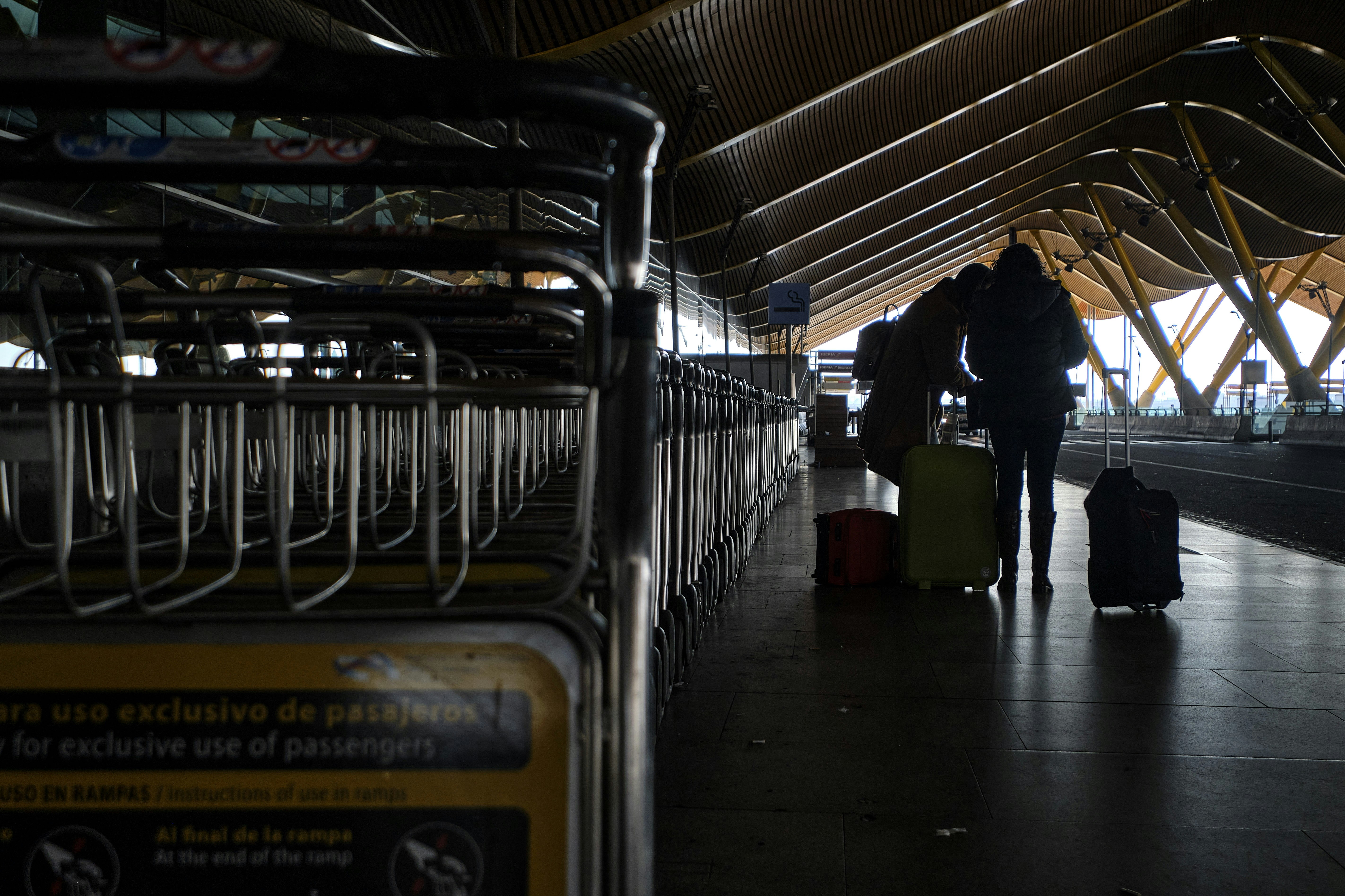 a couple of people standing next to each other with luggage, Waiting the taxi. © arcalle