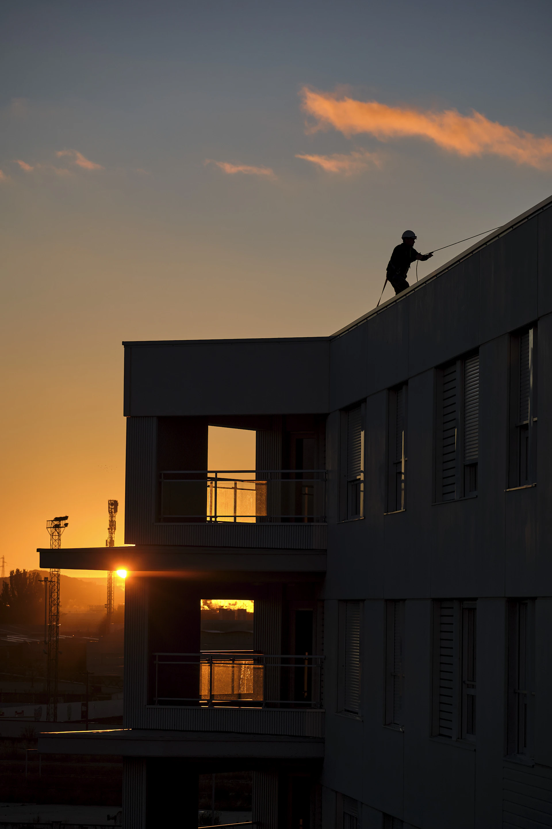 Pintor em rope access ao pôr do sol em São Paulo