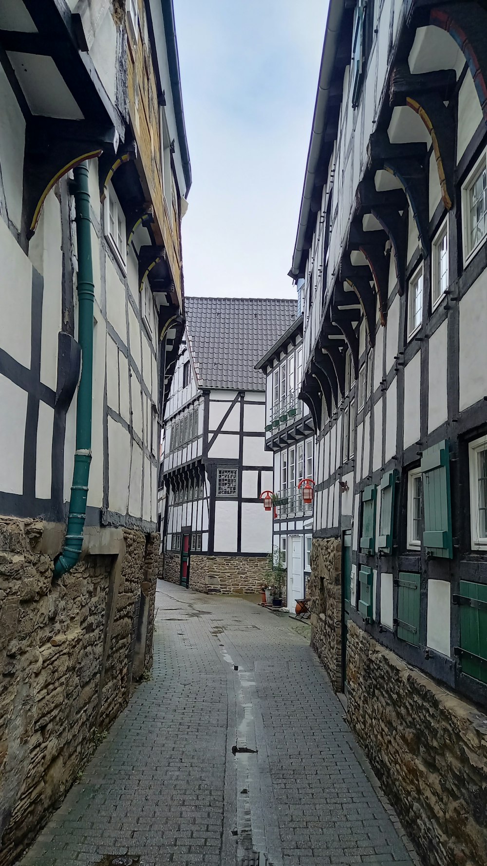 une passerelle pavée entre deux bâtiments anciens