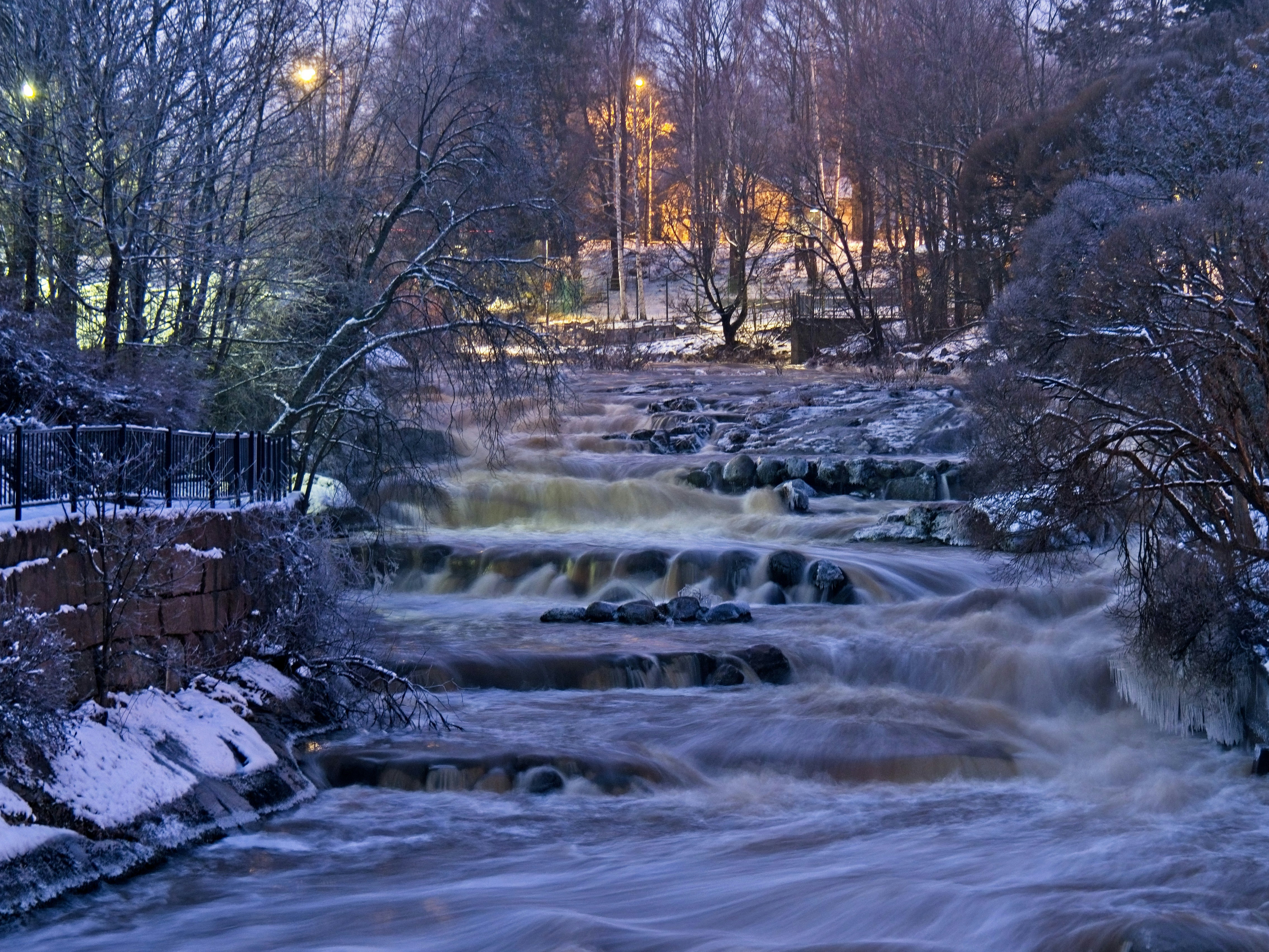 a river running through a forest covered in snow