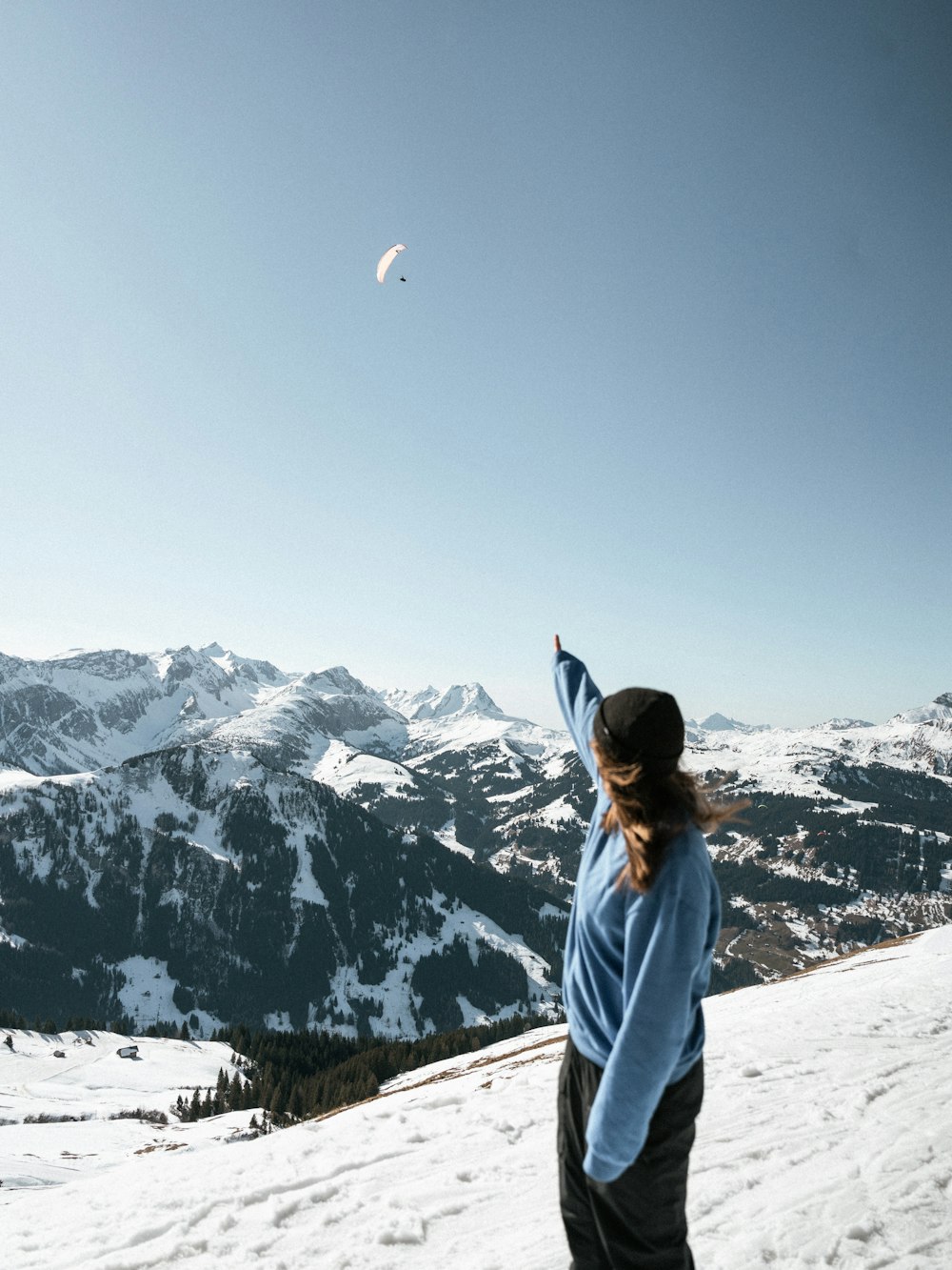 a woman standing on top of a snow covered slope