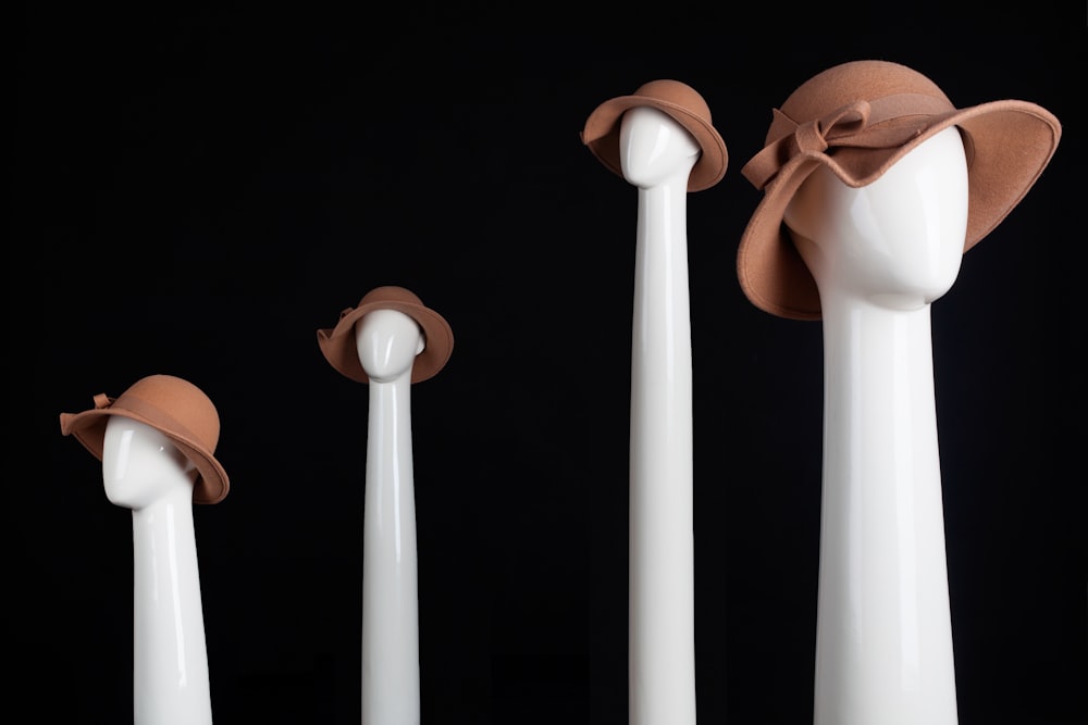 a group of white vases with hats on them