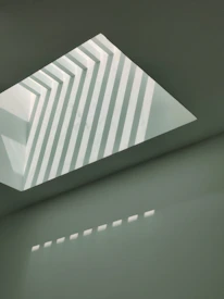 Abstract brutalist shapes in black and gold casting deep shadows.