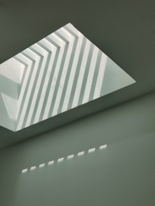 a white room with a slanted ceiling and a skylight