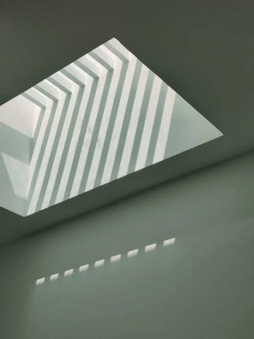 Abstract brutalist shapes in black and gold casting deep shadows.