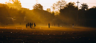 Team huddle held on a misty field, bathed in the soft golden light of dawn.