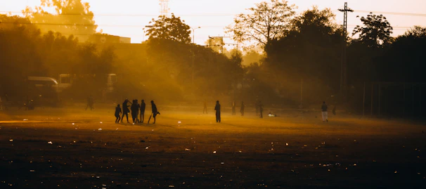 Team huddle held on a misty field, bathed in the soft golden light of dawn.