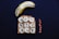 A halved banana sits alongside a slice of toast topped with peanut butter, banana slices, and sprinkled with black seeds. Nearby, a few whole peanuts add a complementary touch to this dark background setup.