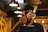 Smiling man holding a branded craft beer glass in a cozy coffee shop setting