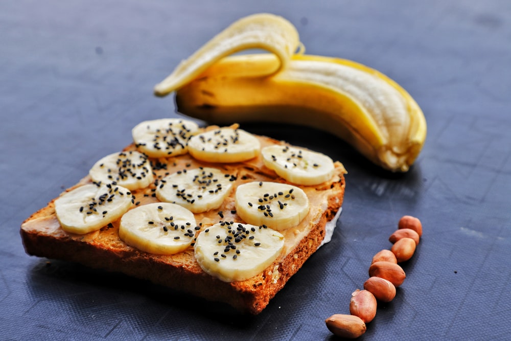 a piece of bread with bananas and nuts on it