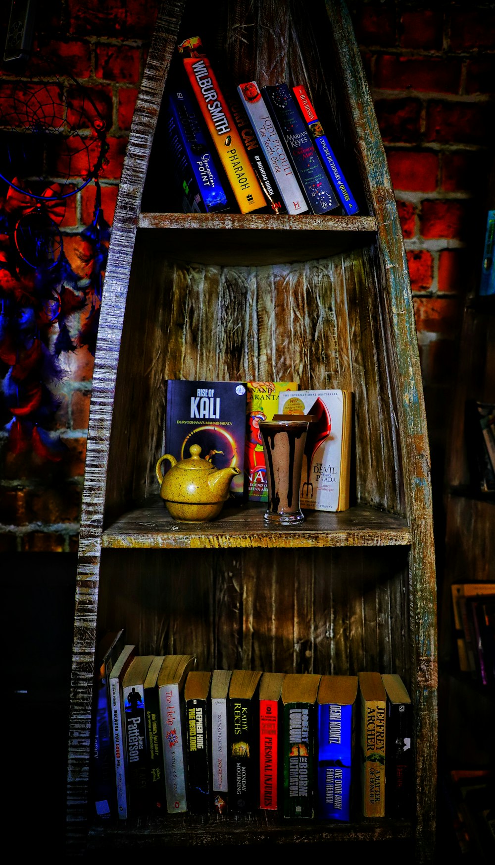 a bookshelf filled with books and a yellow vase