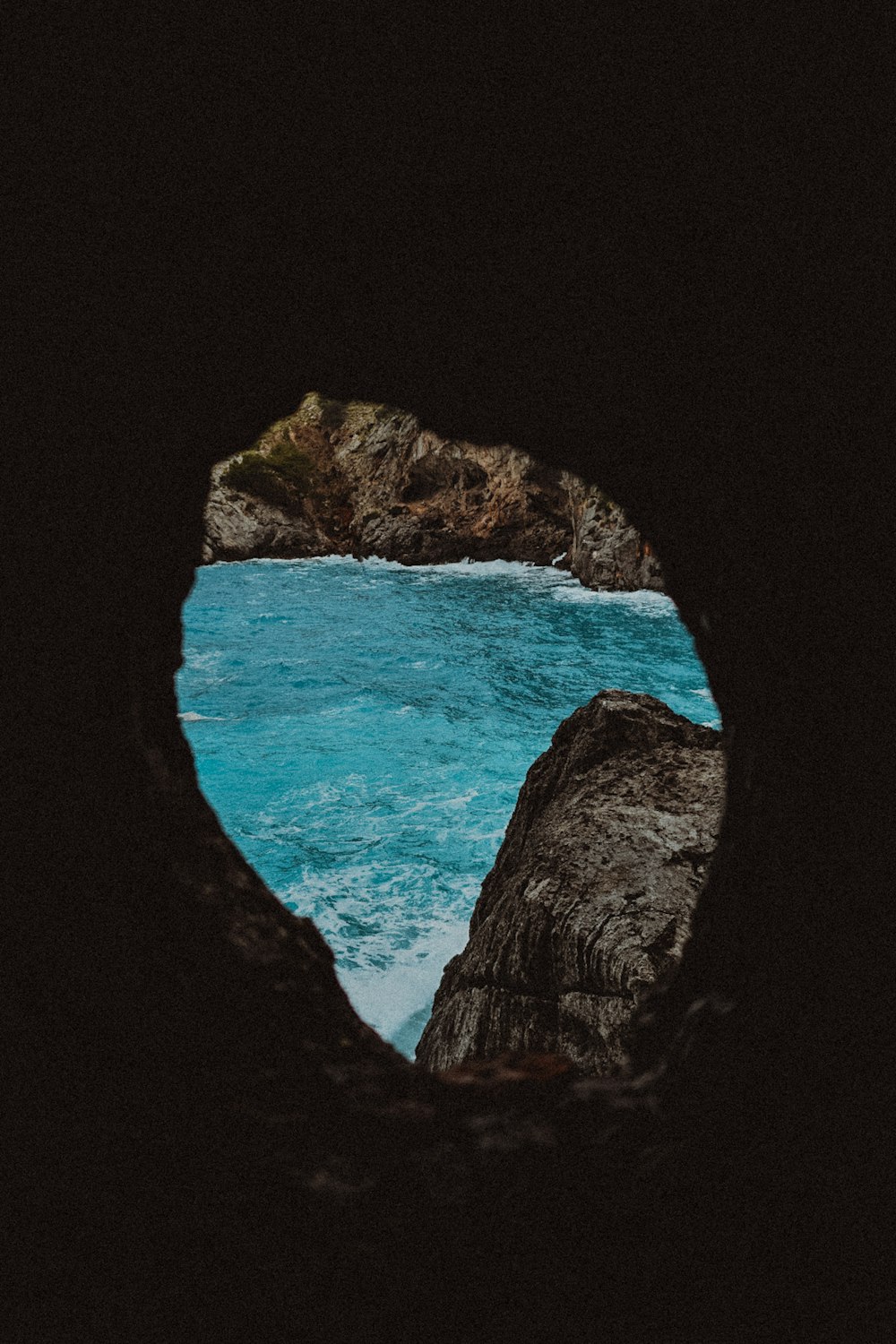 a view of a body of water through a cave