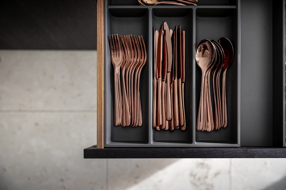 a cabinet with utensils and spoons in it