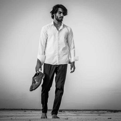 a man standing on a beach holding a baseball glove