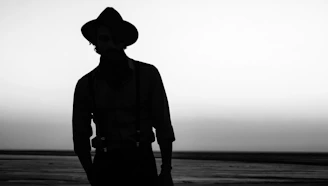 a silhouette of a person wearing a cowboy hat