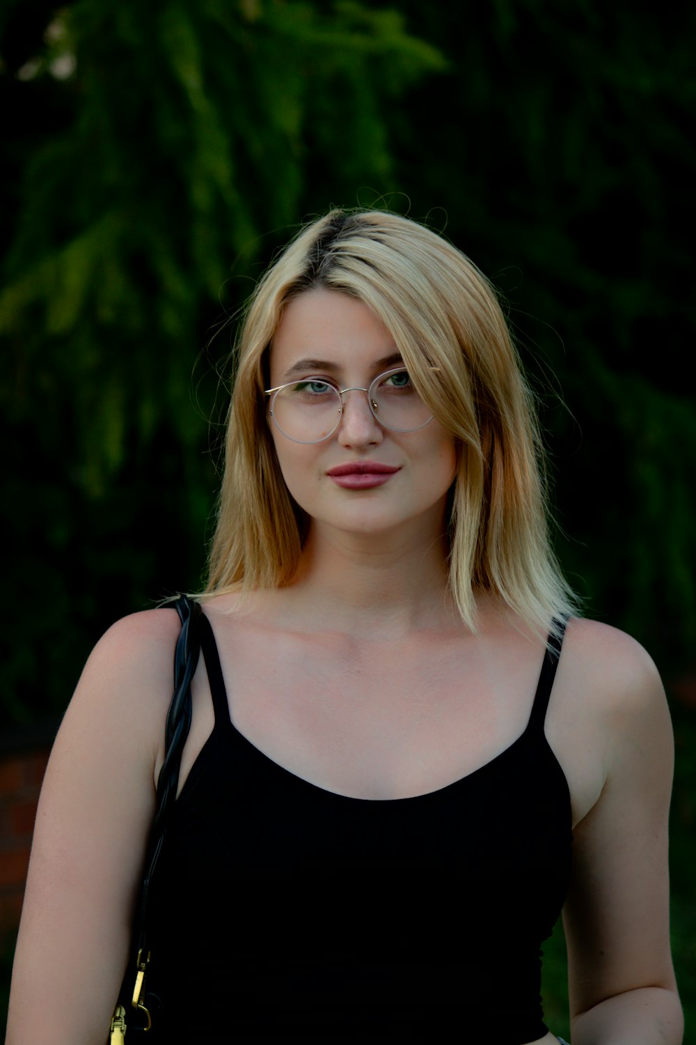 a woman wearing glasses and a black top