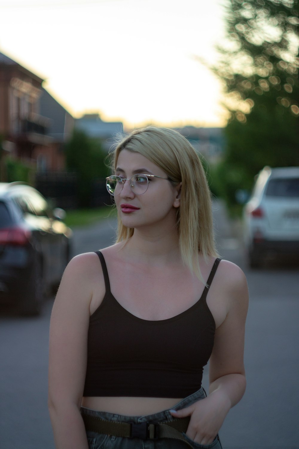 a woman with glasses is standing on the street