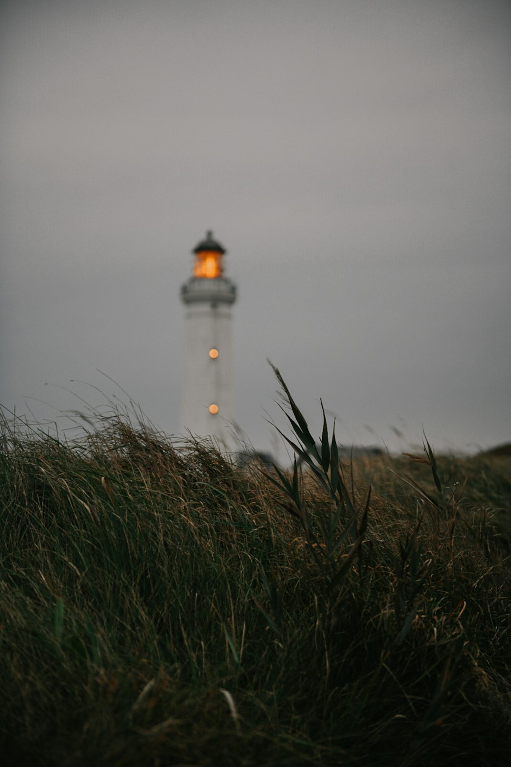 a lighthouse on a foggy day with a yellow light