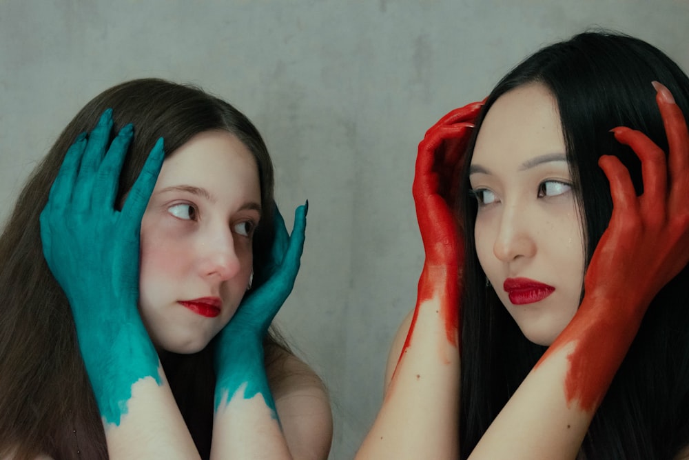 two women with painted hands on their faces