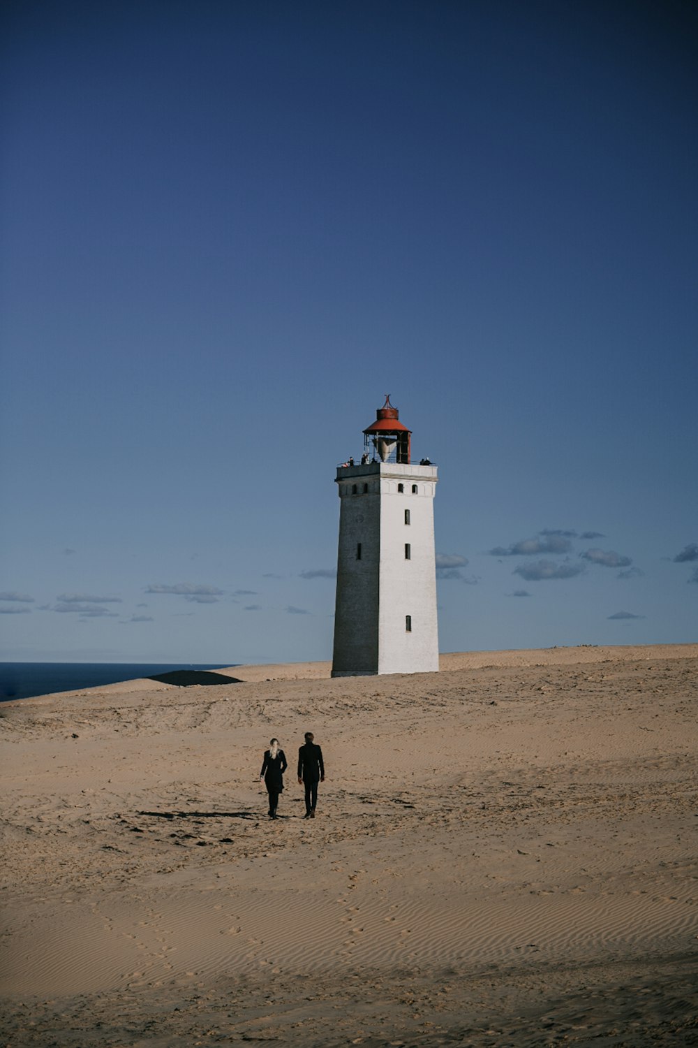 a couple of people that are standing in the sand