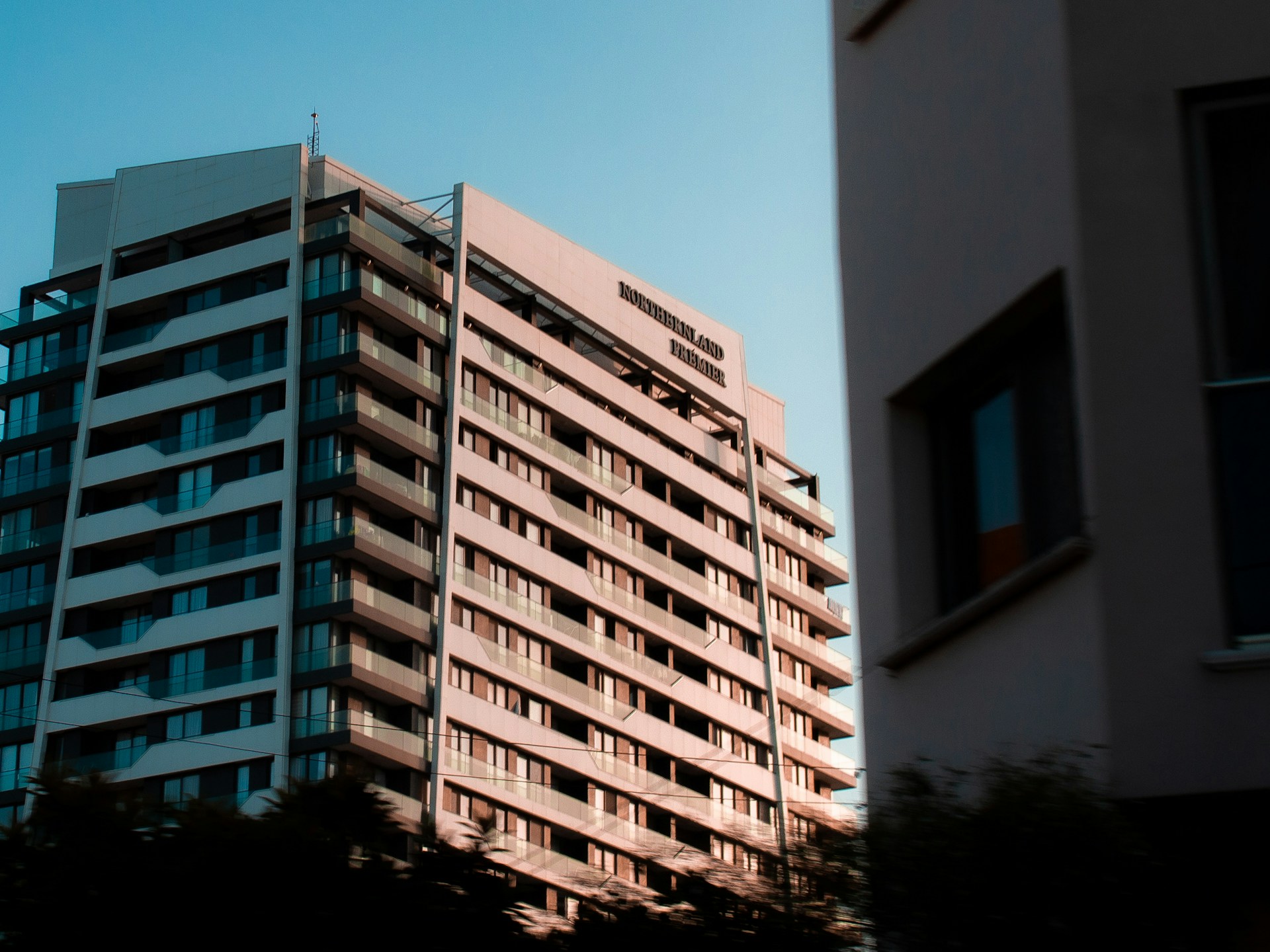a tall building sitting next to a tall white building