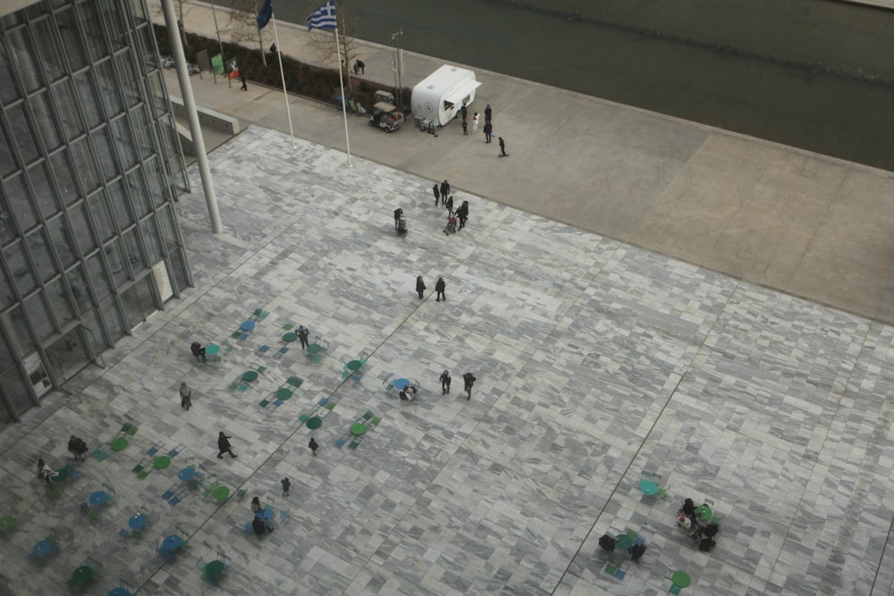 a group of people walking on a sidewalk next to a tall building