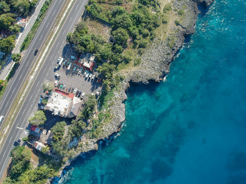 an aerial view of a road next to a body of water