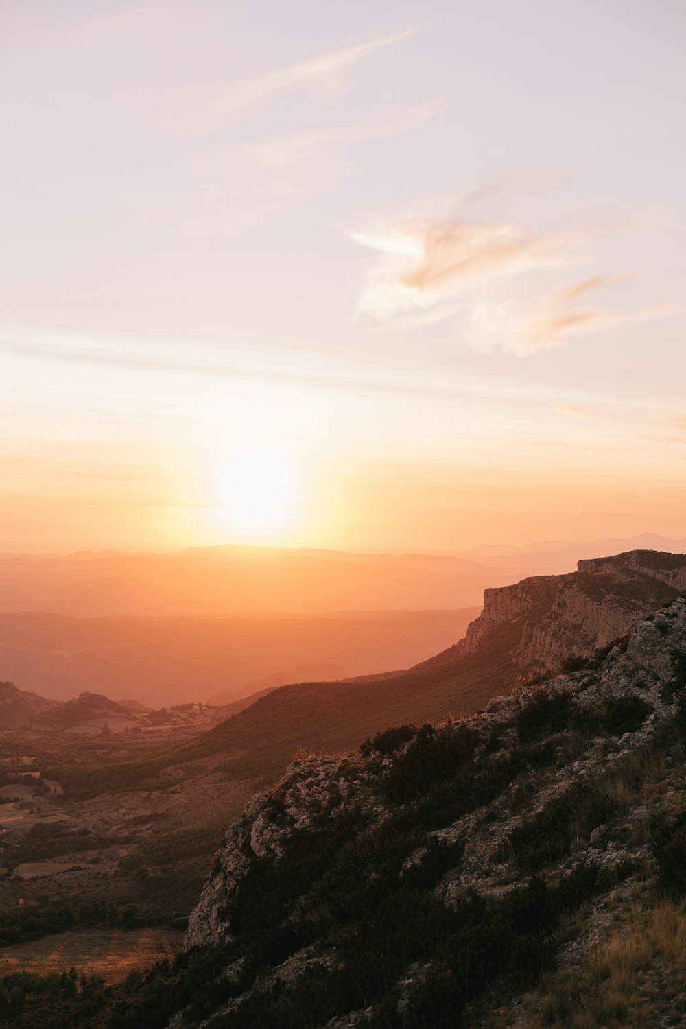 the sun is setting over a rocky hill