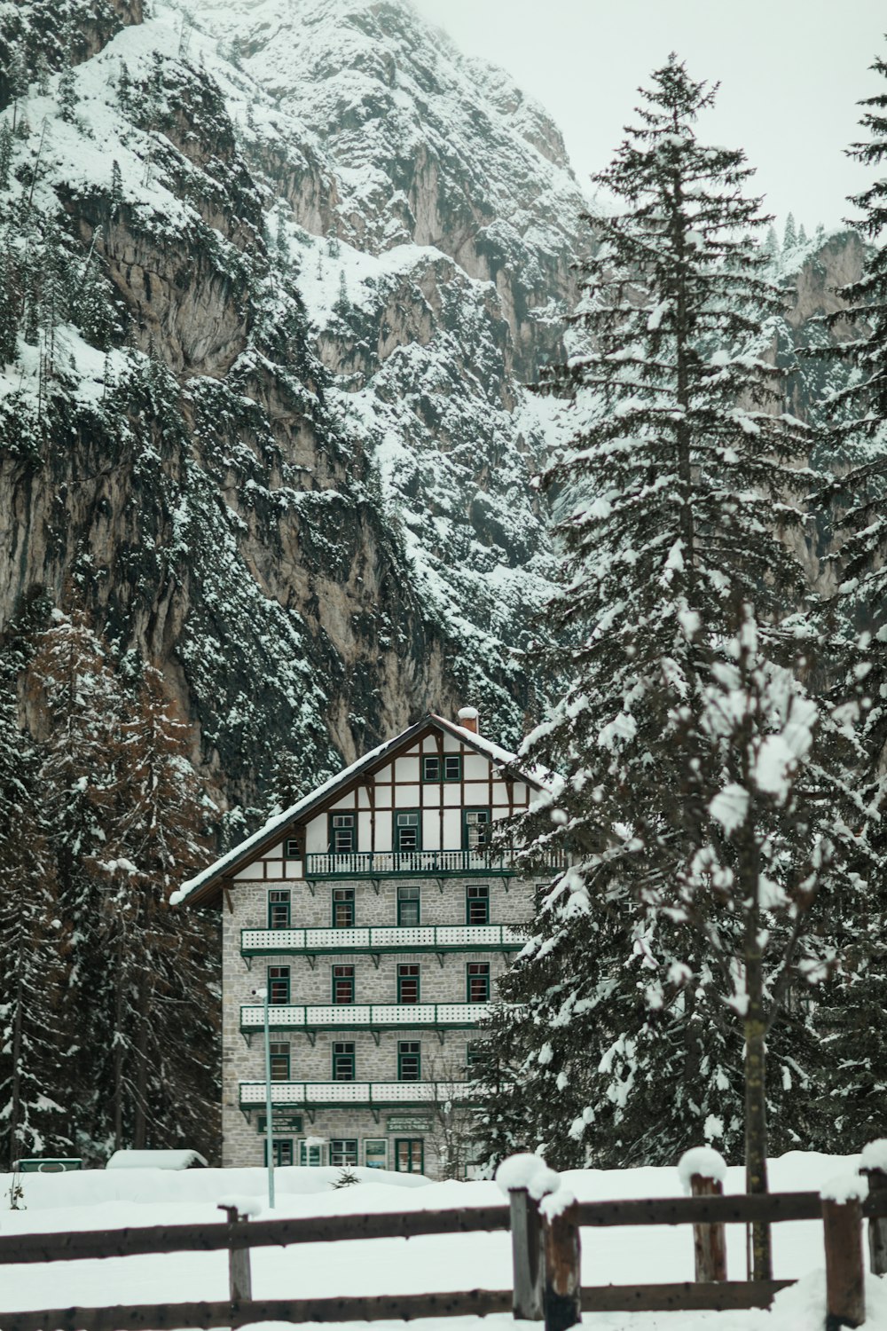 a snow covered mountain with a house in the foreground