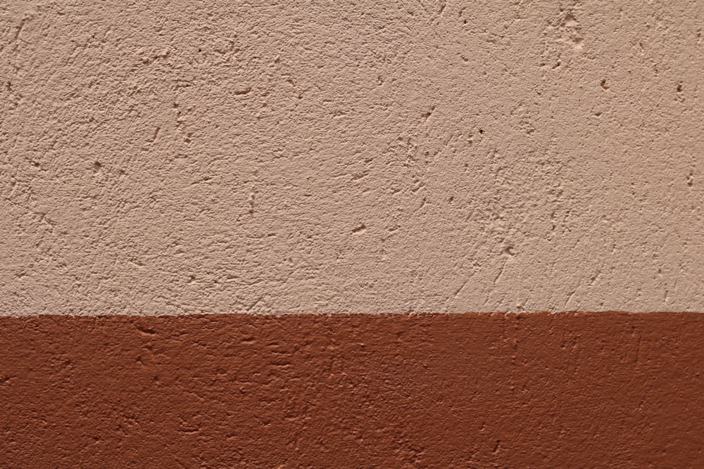 a brown and white wall with a red stripe