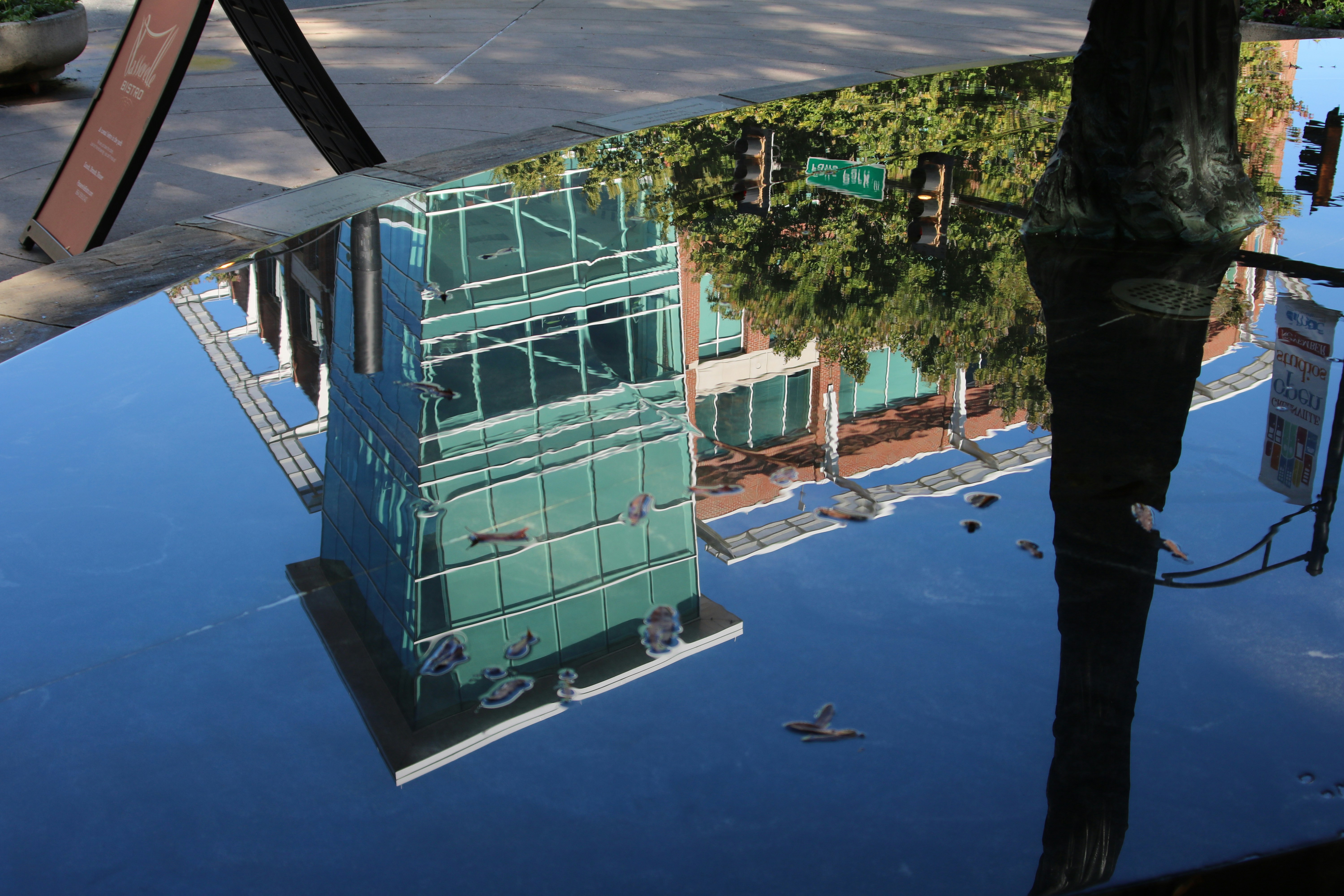 le reflet d’un bâtiment dans une flaque d’eau