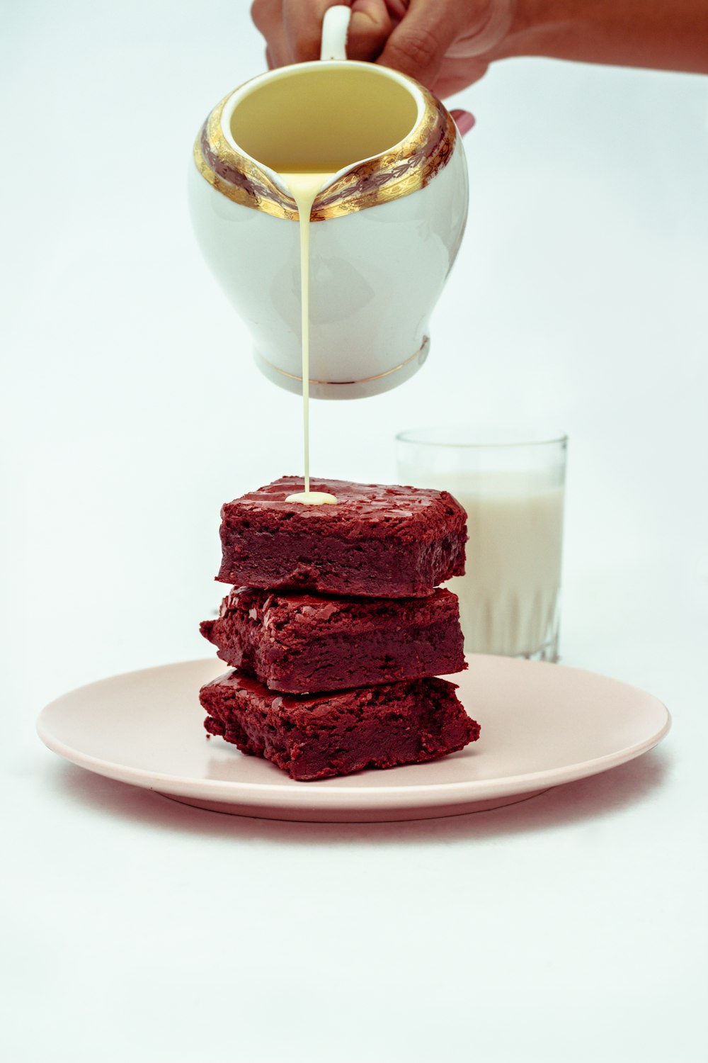 a plate of brownies being drizzled with syrup