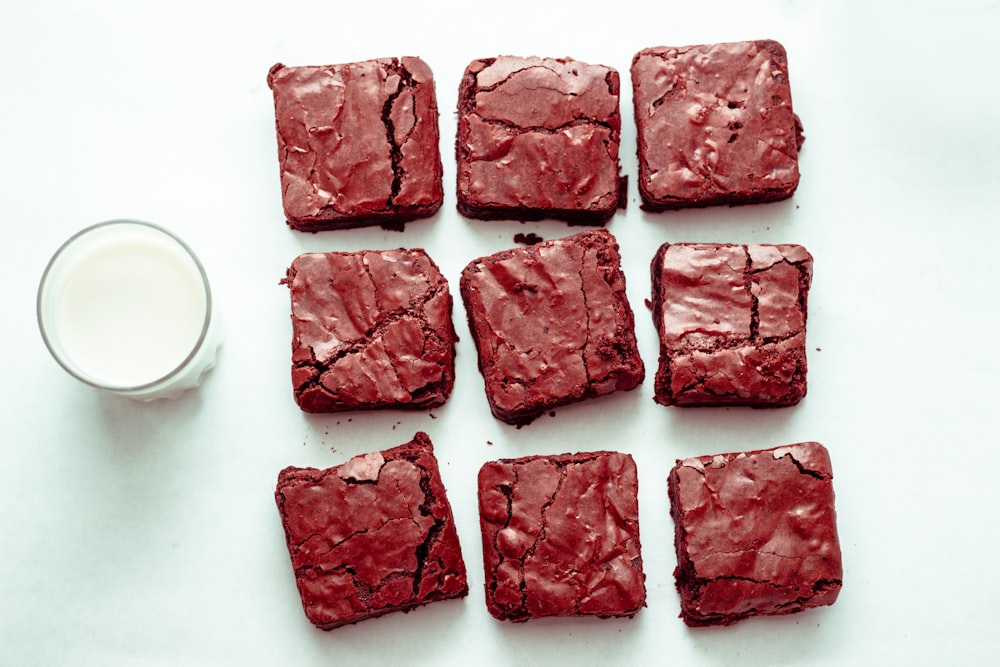 a bunch of brownies sitting next to a glass of milk