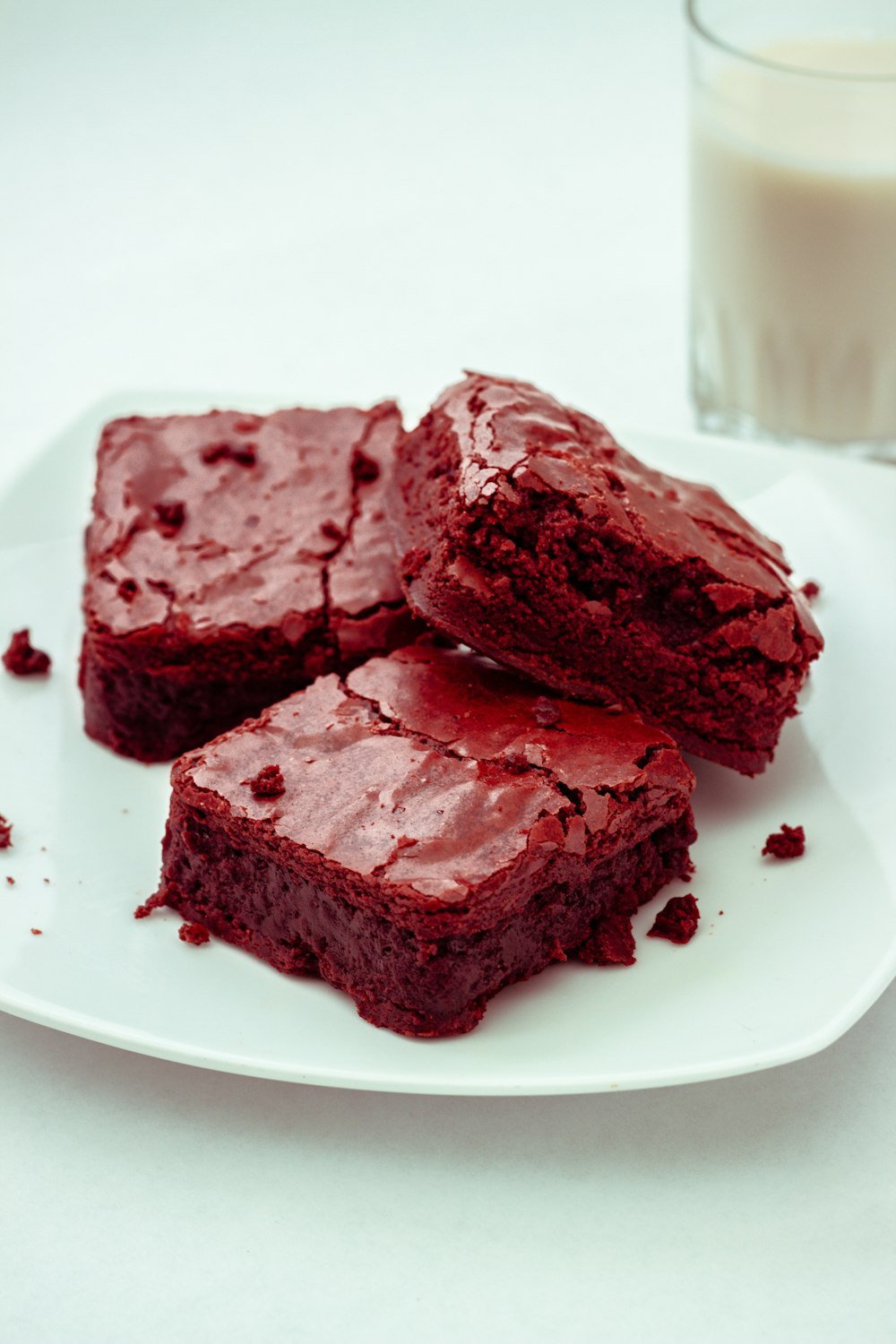 a white plate topped with brownies next to a glass of milk