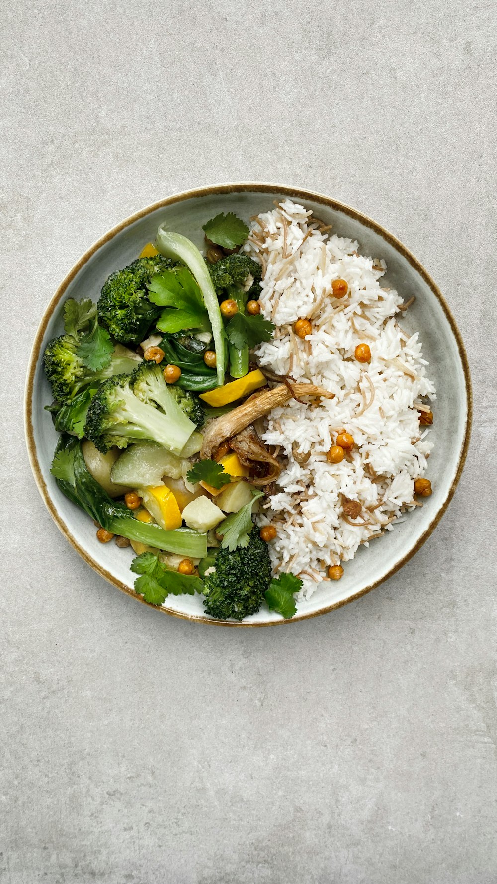 a plate of rice, broccoli, and other vegetables