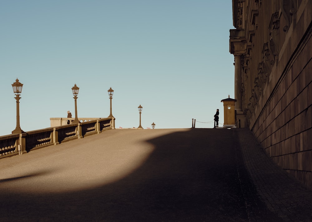 a person standing on a bridge next to a building