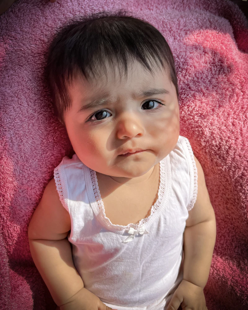 Baby girl lying on a pink blanket