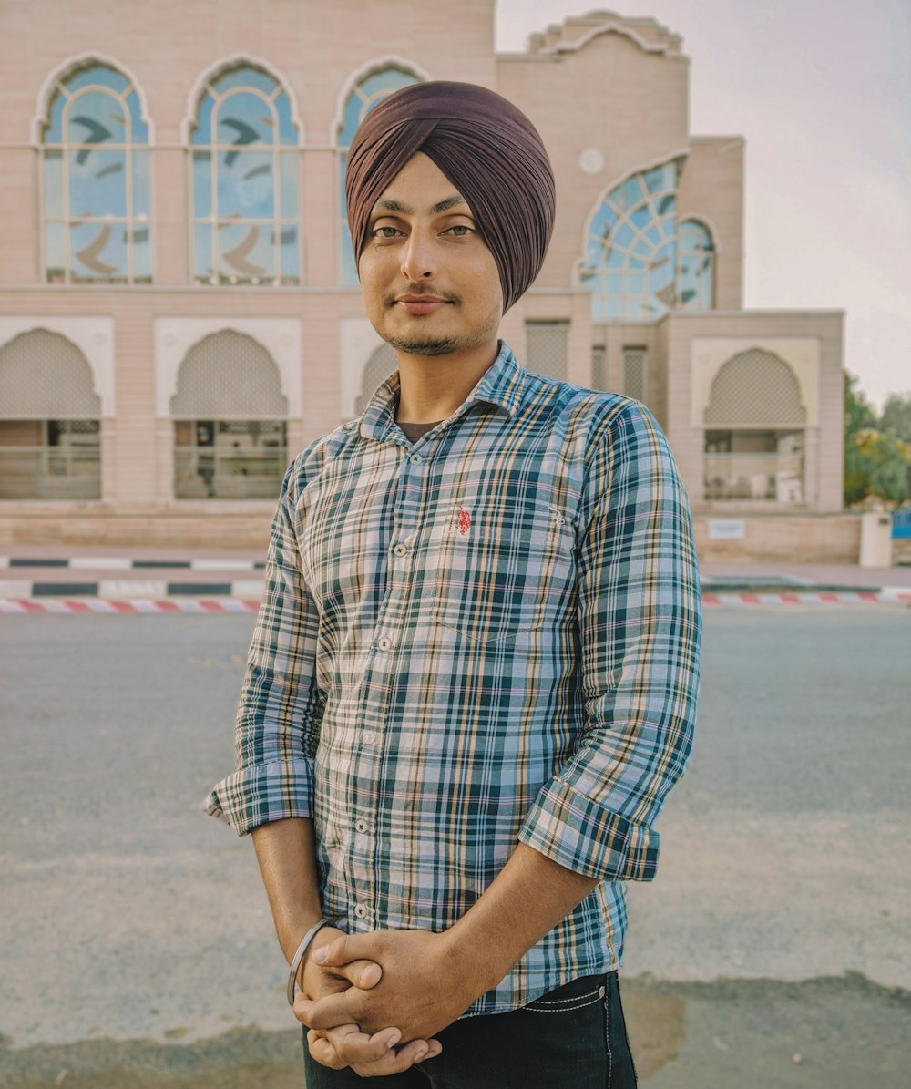 a man in a turban standing in front of a building