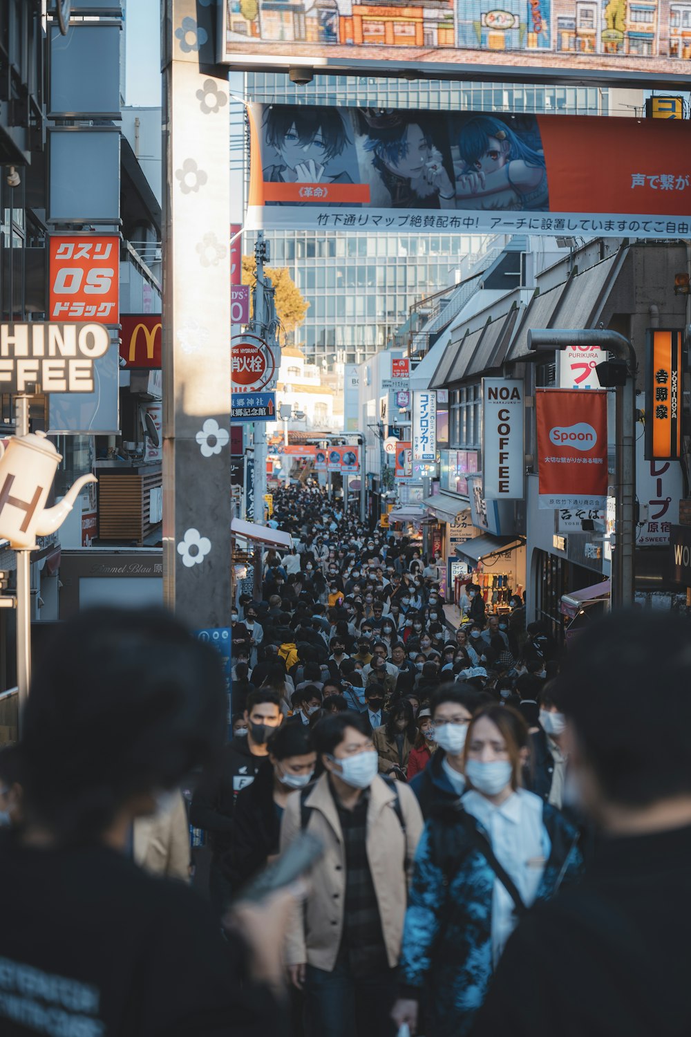 a crowded city street filled with people wearing face masks